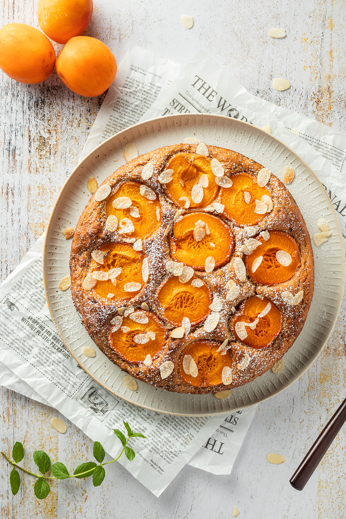 Aprikosenkuchen mit Aprikosenhälften, Mandelblättchen und Puderzucker