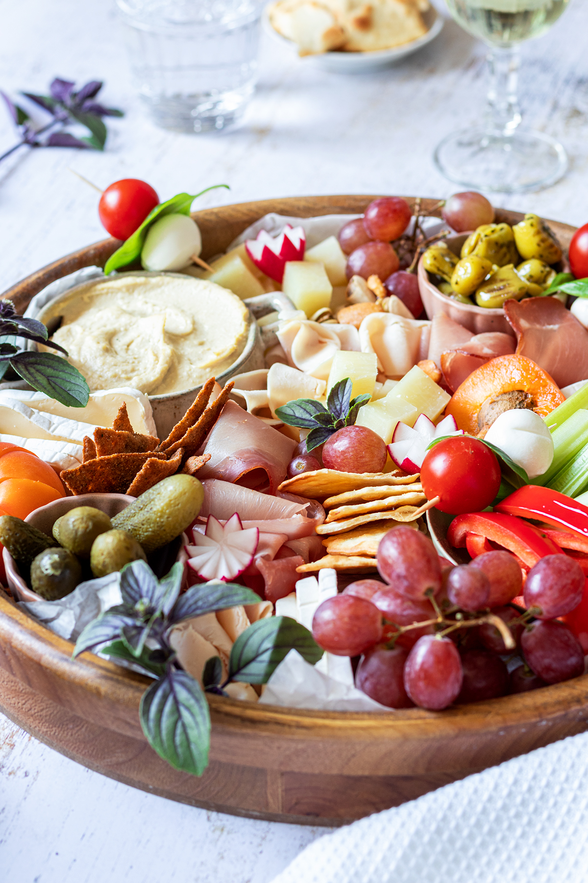 Eine reichlich gef&uuml;llte Brotzeitplatte mit K&auml;se, Schinken, Dips, Gem&uuml;se, Obst und Cracker.