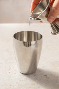 Tequila wird in einen Cocktail Shaker geschüttet