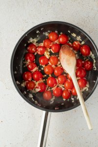 angebratene Schalotten- und Knoblauchwürfel und halbierte Cherrytomaten