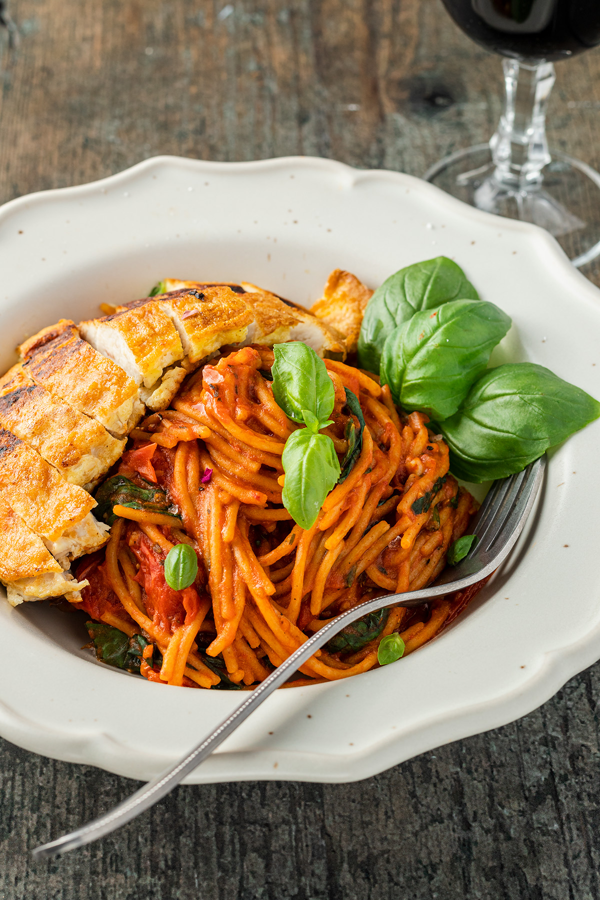H&auml;hnchenbrust Piccata Milanese serviert mit einfachen One Pot Spaghetti und einem Glas Rotwein