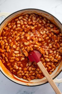 Weiße Bohnen in einer Pfanne mit Tomatensauce.