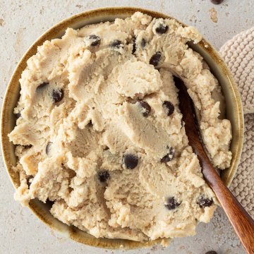 Hüttenkäse Cookie Dough in einer Schüssel mit einem Löffel, Deko und Schokostückchen im Bildrand.