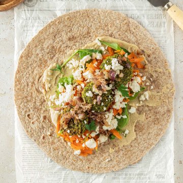 Ein offener Falafel Wrap auf hellem Untergrund mit Deko im Bildrand.