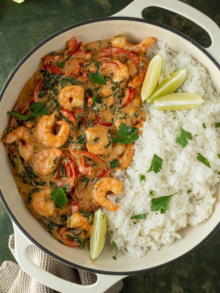Thai Garnelen Curry in einer gro&szlig;en Pfanne mit Reis auf einer Seite.