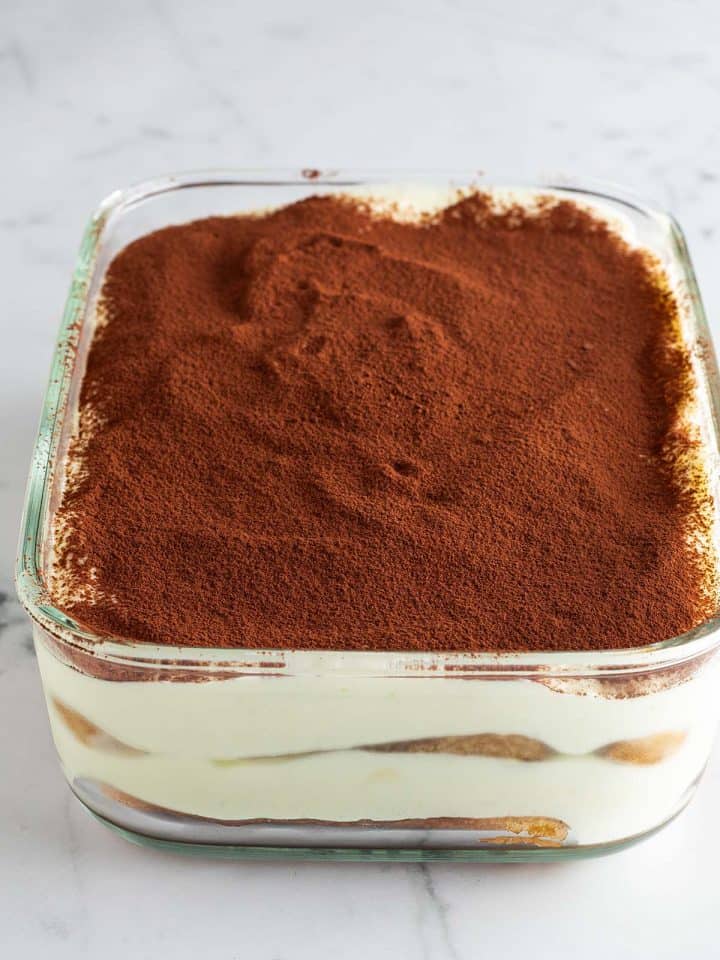 Mit Kakao bestreute Tiramisu ohne Mascarpone und Sahne in einer Glas-Form.