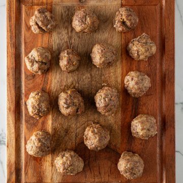 Im Ofen gebackene Hackbällchen auf einem Holzbrett.