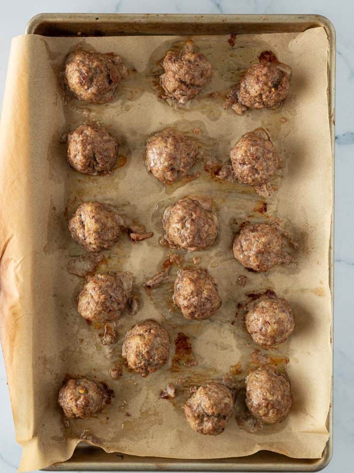 Im Ofen gebackene Hackbällchen auf einem Blech.