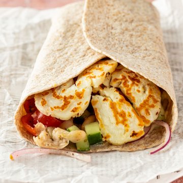 Halloumi Wrap auf einem Stück Zeitungspapier.