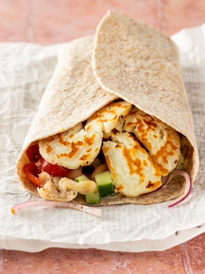 Halloumi Wrap auf einem Stück Zeitungspapier.