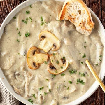 Eine Suppe mit einer cremigen, dickfl&uuml;ssigen Pilzsuppe, serviert mit knusprigen Brot.