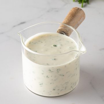 Cremiges selbstgemachtes Ranch Dressing mit frischen Kr&auml;utern in einem kleinen Glasgef&auml;&szlig;.
